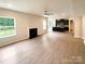 Open concept: living room with fireplace flows into the kitchen with island, enhancing connectivity and space at 2382 Drake Mill Sw Ln, Concord, NC 28025