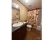 This bathroom features a brown vanity and a shower/tub combination with a decorative curtain at 2418 6Th Sw Ave, Hickory, NC 28602