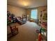 A bedroom features a twin bed, a toy kitchen and shelving filled with toys at 2418 6Th Sw Ave, Hickory, NC 28602