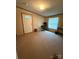 An empty living room with neutral carpet has a work desk, a window, and a white front door at 2418 6Th Sw Ave, Hickory, NC 28602