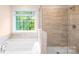 Luxurious bathroom with a soaking tub, tiled shower, and a large window offering natural light at 259 Miramar Dr, York, SC 29745