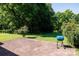 An outside brick patio with a blue grill and lush green space perfect for outdoor relaxation and entertainment at 2765 Dogwood Cir, Rock Hill, SC 29732