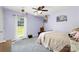 Cozy bedroom with a large window, soft lavender walls, and carpet flooring is illuminated by a ceiling fan at 2765 Dogwood Cir, Rock Hill, SC 29732