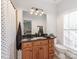 Bathroom with wood vanity, dark countertop, and a large mirror with decorative lighting at 3036 Luke Crossing Dr, Charlotte, NC 28226