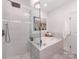 Bathroom boasts a separate shower and tub setup with elegant white tiling and a modern shower head at 3036 Luke Crossing Dr, Charlotte, NC 28226