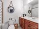 Bathroom with wood vanity, decorative round mirrors, and toilet at 3036 Luke Crossing Dr, Charlotte, NC 28226