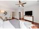 Bright bedroom features a ceiling fan, sleek dresser with TV, and an elegant fish art piece on the wall at 3036 Luke Crossing Dr, Charlotte, NC 28226