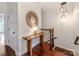 Hallway with decorative mirror, wood console table, and hardwood floors leading to staircase at 3036 Luke Crossing Dr, Charlotte, NC 28226