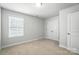 Bedroom features a large window, a closet with double doors, and neutral carpeting at 334 Ladybird Ln, Pineville, NC 28134