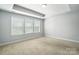 Inviting bedroom with neutral carpet features a trey ceiling and abundant natural light from large windows at 334 Ladybird Ln, Pineville, NC 28134