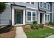 Inviting townhome exterior featuring gray siding, white trim, a well-maintained lawn, and a teal front door at 334 Ladybird Ln, Pineville, NC 28134