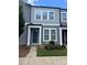 Charming townhome featuring gray siding, white trim, a quaint front garden, and a welcoming teal front door at 334 Ladybird Ln, Pineville, NC 28134