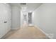 Upstairs hallway with tan carpet and white walls, with doors leading to other rooms at 334 Ladybird Ln, Pineville, NC 28134