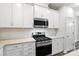 Close-up of a kitchen features white cabinets, a gas stove, and stainless steel appliances at 334 Ladybird Ln, Pineville, NC 28134
