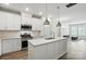Bright kitchen with stainless appliances, white cabinets, a large island, and open to living room at 334 Ladybird Ln, Pineville, NC 28134