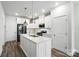 Bright kitchen with white cabinets, an island with a sink, and stainless steel appliances at 334 Ladybird Ln, Pineville, NC 28134