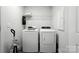 Functional laundry room with modern washer and dryer, plus shelving, ensures effortless chores at 334 Ladybird Ln, Pineville, NC 28134