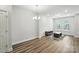Bright living room boasts wood floors, a modern light fixture, and a cozy area rug at 334 Ladybird Ln, Pineville, NC 28134