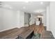 Spacious living area showcasing wood-look floors, neutral walls, an open staircase, and a view of the kitchen at 334 Ladybird Ln, Pineville, NC 28134