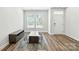 Bright living room with wood floors, large windows, modern furniture, and fresh paint at 334 Ladybird Ln, Pineville, NC 28134