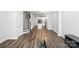 Bright, open-concept living area with wood-look flooring, stairs to the upper level, and a view of the kitchen at 334 Ladybird Ln, Pineville, NC 28134
