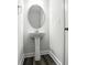 This powder room features a white pedestal sink, modern mirror and fixtures at 334 Ladybird Ln, Pineville, NC 28134