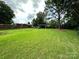 Large, well-maintained backyard with mature trees and a swing set at 3396 Farm Lake Sw Dr, Concord, NC 28027