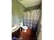 Compact bathroom with laminate floor, toilet, vanity, and shower with blue shower curtain at 3396 Farm Lake Sw Dr, Concord, NC 28027
