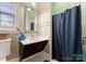 Bathroom featuring a modern vanity, decorative mirror, and shower with a dark blue curtain providing privacy at 408 Covington Xing, Matthews, NC 28104