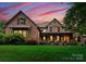 Stunning brick home boasts a covered porch, manicured lawn, and lush landscaping at 408 Covington Xing, Matthews, NC 28104