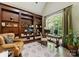 Stylish home office with custom built-in bookshelves, a large window, and a comfortable seating area at 408 Covington Xing, Matthews, NC 28104