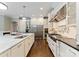 Bright kitchen features a large island, stainless steel appliances, white cabinets, and hardwood floors at 408 Covington Xing, Matthews, NC 28104