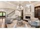 Cozy living room with a stone fireplace, classic chandelier, and staircase at 408 Covington Xing, Matthews, NC 28104