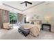 Comfortable main bedroom featuring a large window, sitting area, tray ceiling, and neutral decor with modern accents at 408 Covington Xing, Matthews, NC 28104