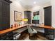 Well-lit office space with built-in shelves, custom cabinets, and a large window, creating a functional work area at 408 Covington Xing, Matthews, NC 28104