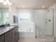 Luxurious bathroom featuring a soaking tub, walk-in shower, and granite-topped vanity at 4177 Steel Way, Sherrills Ford, NC 28673