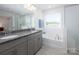 Elegant bathroom featuring a soaking tub, walk-in shower, and granite-topped vanity at 4177 Steel Way, Sherrills Ford, NC 28673