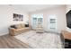 Cozy living room featuring a beige sofa, a patterned rug, and a bright window with a backyard view at 4177 Steel Way, Sherrills Ford, NC 28673