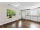 Bright kitchen featuring white cabinets, laminate floors, and natural light from a large window at 429 Merry Go Dr, York, SC 29745