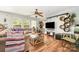 Bright living room featuring hardwood floors, a comfortable couch, and large windows at 4312 Mary Point Rd, Monroe, NC 28110