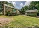 Well-manicured backyard with a spacious lawn, mature trees, and a cozy deck area, perfect for outdoor entertaining at 5014 Quail Canyon Dr, Charlotte, NC 28226