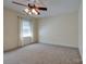 Bright and airy bedroom featuring neutral carpet, large windows, and ceiling fan at 5014 Quail Canyon Dr, Charlotte, NC 28226