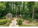 Picturesque backyard featuring a greenhouse, chicken coop, raised garden beds and lush surrounding greenery at 5014 Quail Canyon Dr, Charlotte, NC 28226