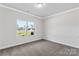 A bright bedroom with a carpeted floor and a large window overlooking the neighborhood at 5208 Admirals Lndg, Lancaster, SC 29720