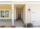 Inviting front porch with stone accents, a stylish front door, and exterior lighting at 5208 Admirals Lndg, Lancaster, SC 29720