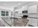 Close-up of kitchen island featuring granite countertops, stainless steel sink, and modern appliances at 5208 Admirals Lndg, Lancaster, SC 29720