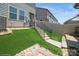 Artificial grass backyard with stone and stair access at 5391 Orchid Bloom Dr, Indian Land, SC 29707