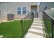 Backyard with artificial grass and stairs to the upper level at 5391 Orchid Bloom Dr, Indian Land, SC 29707