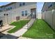 Landscaped backyard featuring stairs to the back door, a small turf yard, and a fenced perimeter for privacy and relaxation at 5391 Orchid Bloom Dr, Indian Land, SC 29707