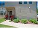 Inviting front entrance with a covered porch and colorful potted plants at 5391 Orchid Bloom Dr, Indian Land, SC 29707